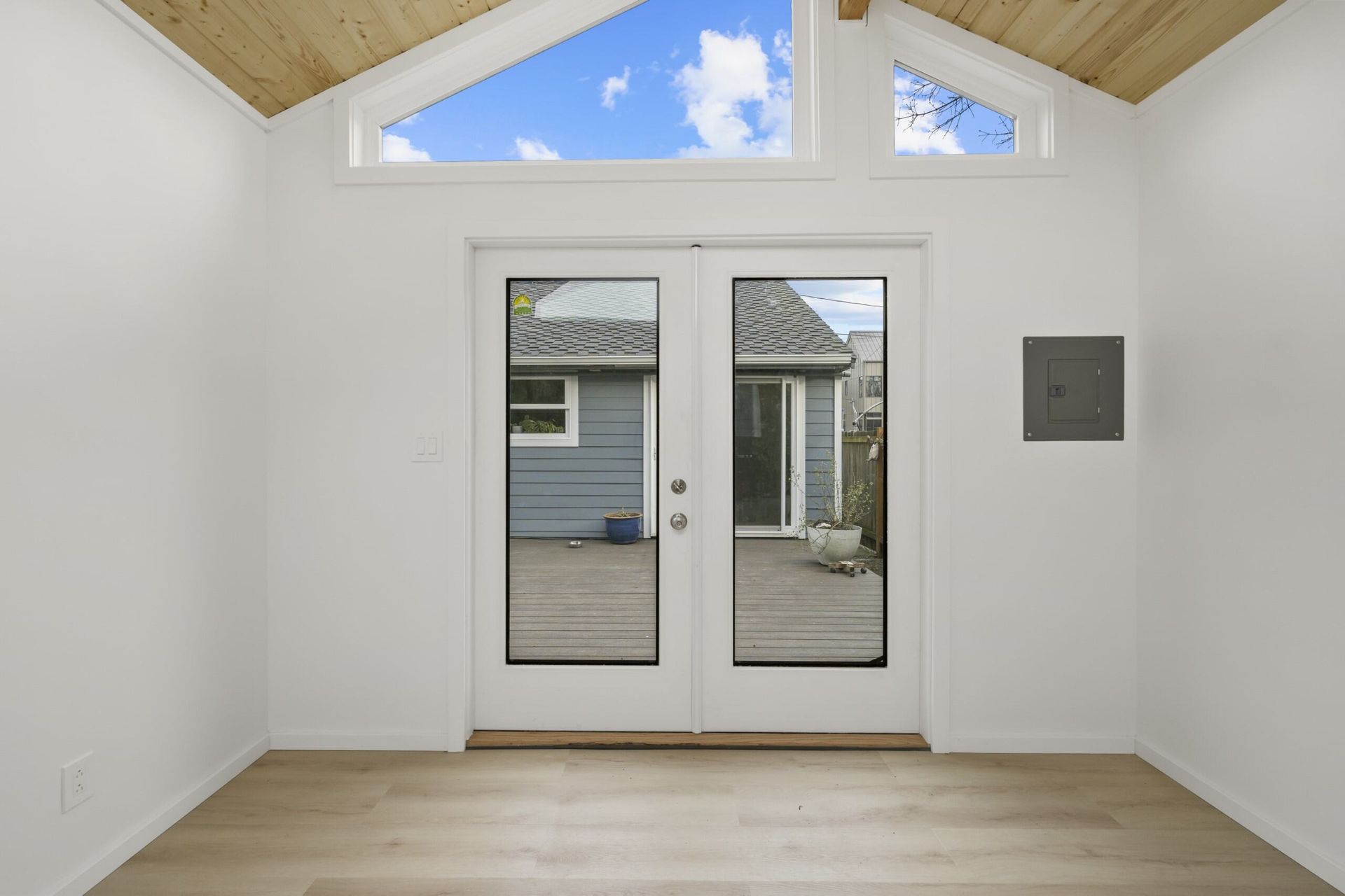Empty room with vaulted ceiling and large window