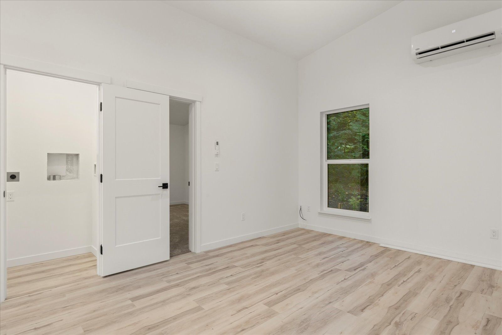 Empty room with hardwood floors and white walls